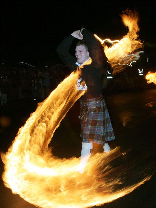 Men parading with fireballs through the streets.