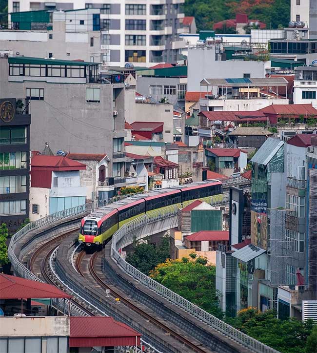 The metro train passes through a densely constructed area