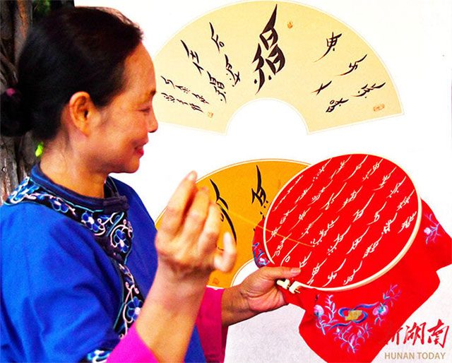 A woman hand-embroiders characters of Women's Script following the custom of the Third Day Letter.