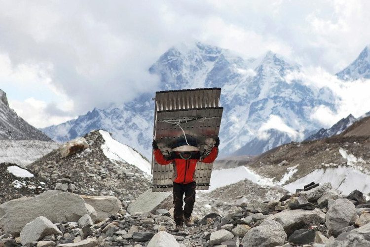 A Sherpa carries a ladder for climbers attempting to summit Everest.