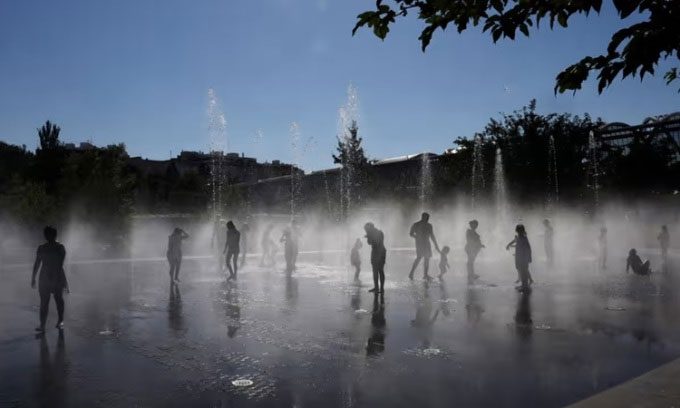 People cool off under a fountain in Madrid Rio park in Madrid on July 23.