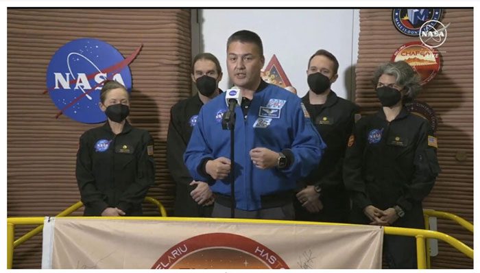 A NASA official speaks, with scientists who just exited the test area behind