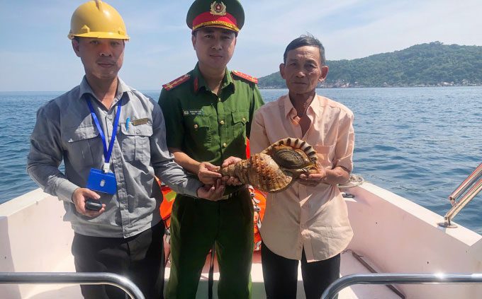 Mr. Cu and authorities releasing the conch back into the sea.