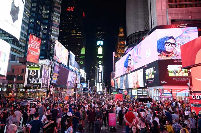 Millions of Americans gather in Times Square waiting for the ball drop at midnight