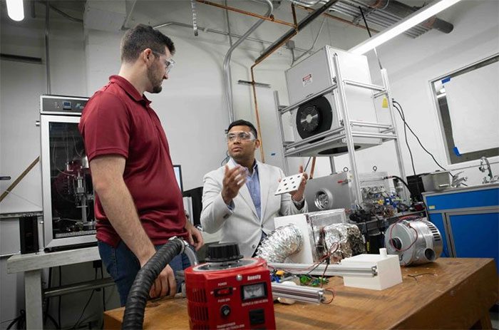 Professor Sameer Rao (right) describes the device for harvesting fresh water from the atmosphere