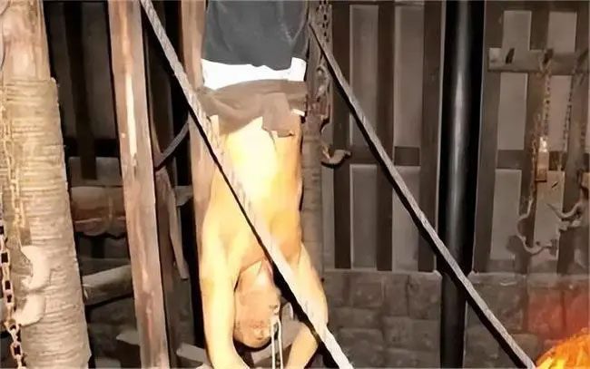 The prisoner is hung upside down while eating noodles, causing them to choke.