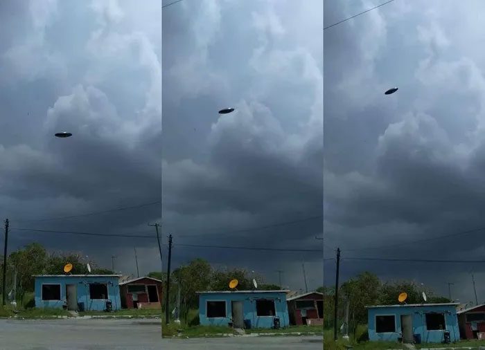 The mysterious object alleged to be a UFO hovering in front of a dark cloud.