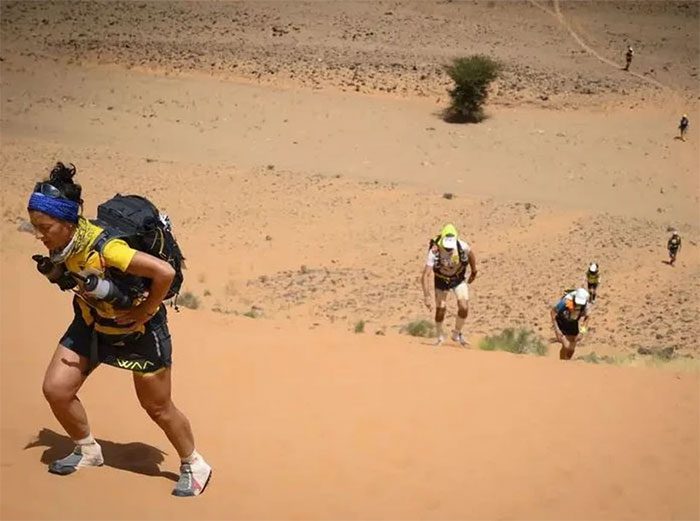 A female athlete and others participating in the Marathon des Sables