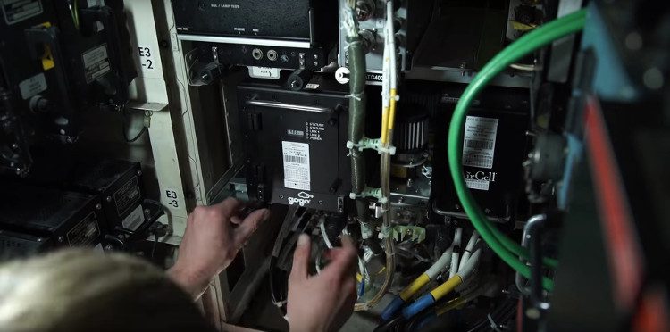 A technician is installing the satellite connection unit on a Boeing 747.