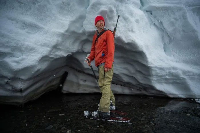 Brian Buma collecting samples from different layers of the Arctic glacier.