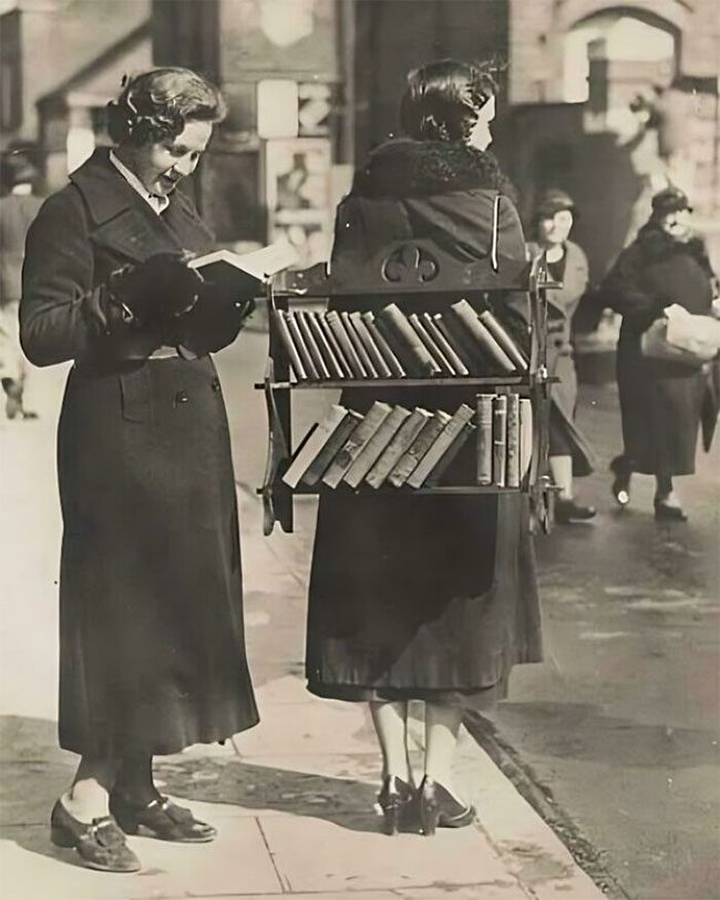 A 'mobile library' with a woman offering books for loan.