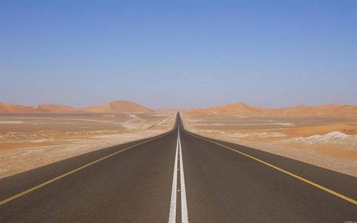 The straight road stretches endlessly in Saudi Arabia.