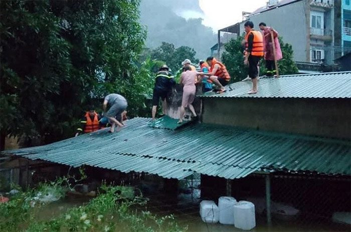 Rapidly rising floodwaters forced many families to climb onto their roofs waiting for rescue