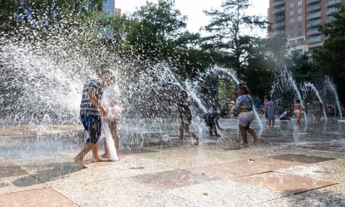 Residents cool off under a water fountain in Houston, Texas.