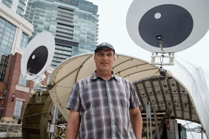 Founder John Kellett proudly stands beside one of the company's trash filtering devices.