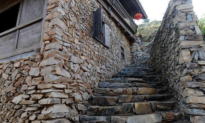 The village preserves many historical cultural features with yellow walls, black bricks, wooden houses, and stone stairs everywhere.