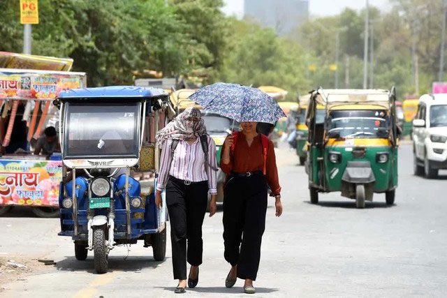 Residents protect themselves from summer heat in Gurugram, India on June 18, 2024.