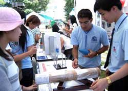 Student Nguyen Thanh Binh from 10th grade explaining the principle of the center of gravity through a physics experiment with visiting students