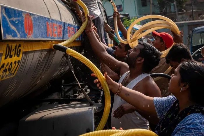 People gather to get water in hot weather in New Delhi, India.