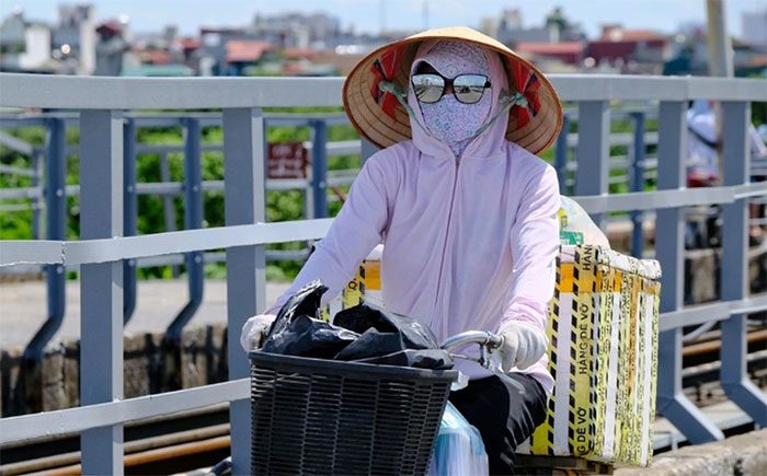 A resident of Hanoi dressed heavily while out in the midday sun