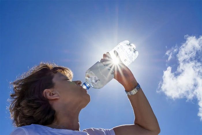 Drinking bottled water under sunlight