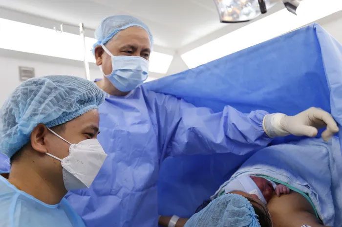 The Director of Tu Du Hospital is the lead surgeon.