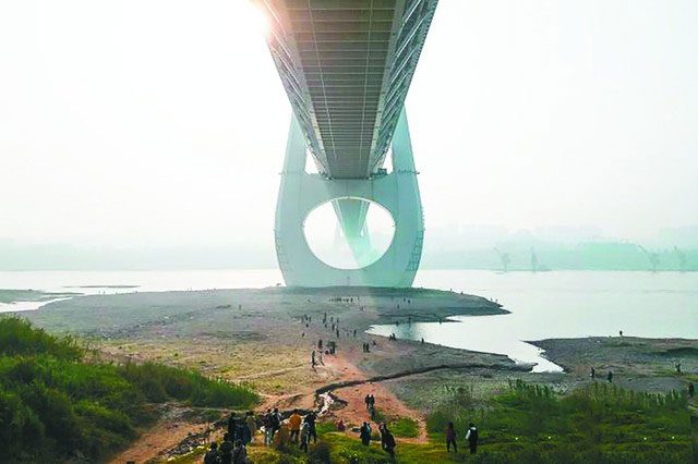 Tourists taking photos under the bridge.