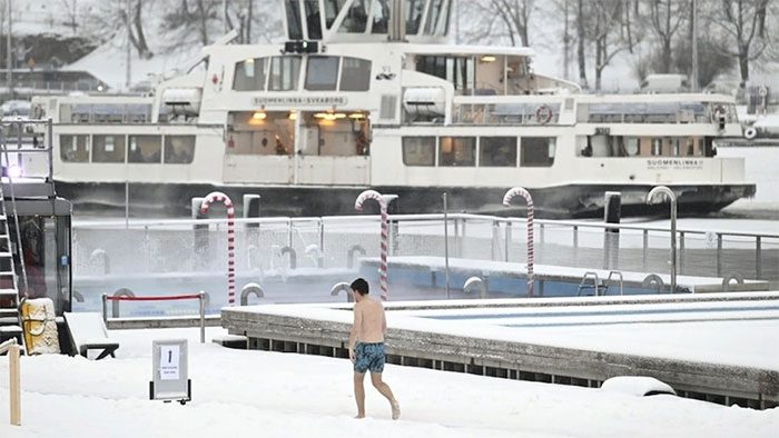 A man walking past the Allas Sea Pool in southern Helsinki, Finland