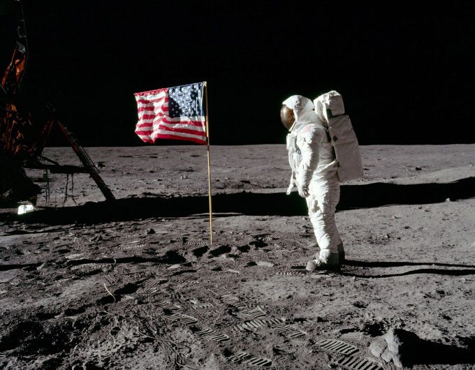 Astronaut Buzz Aldrin stands with the American flag on the Moon during the Apollo 11 mission