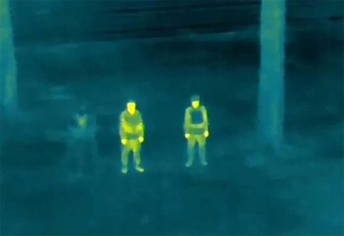 A person wearing the cloaking garment is nearly invisible next to two soldiers without cloaks