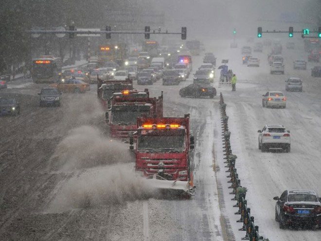 Snowplows operating on the streets during the snowstorm in Harbin