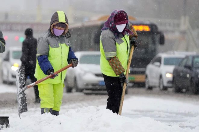 Workers clearing snow to allow traffic to pass