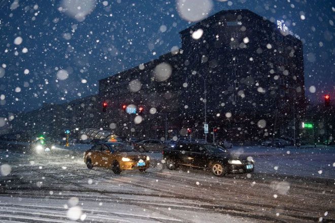 Vehicles moving through heavy snowfall in Heilongjiang