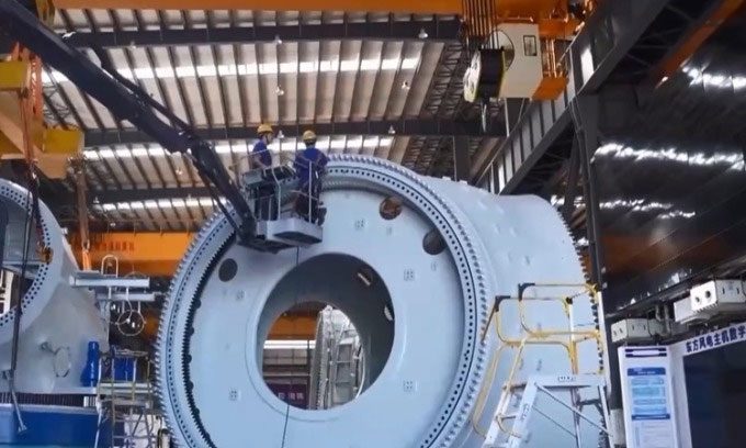 Workers inspecting a main component of the 18 MW wind turbine.