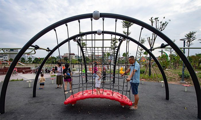 The children's playground features slides, swings, and animal-shaped seating...