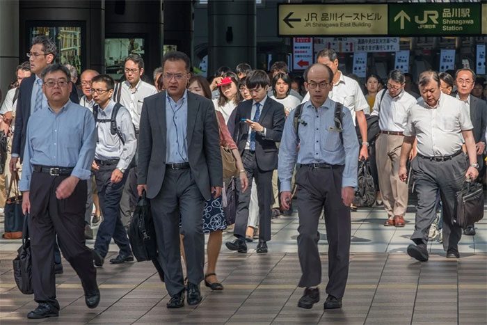 A crowd of office workers in Japan at a train station in Tokyo.
