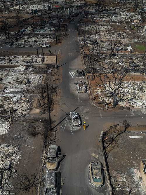 A firefighter walks alone among the ruins in the historic town of Lahaina
