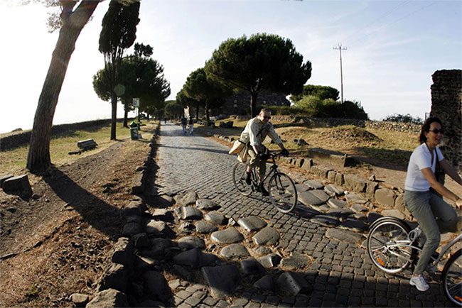A cyclist rides along the Appian Way in Rome