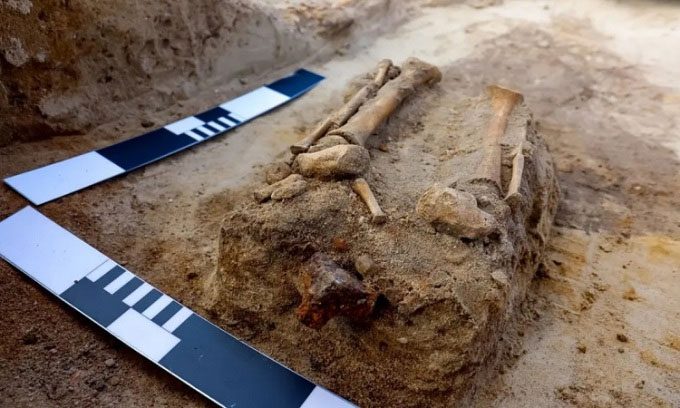 Child's skeleton buried with iron clamp in the grave.