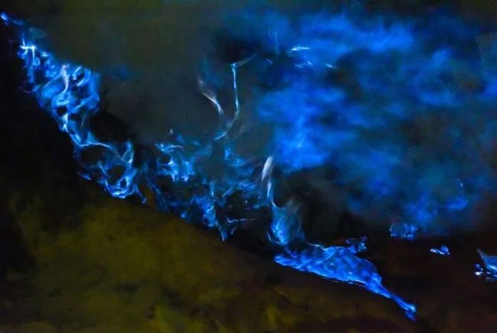 The blue flames erupt from the ground, visible only at night