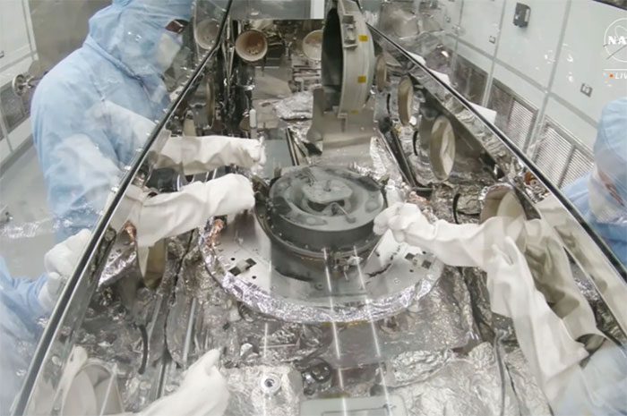 NASA scientists working with the sample container