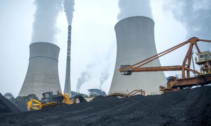 Bulldozer pushing coal onto a conveyor belt at the Jiangdu power plant in Sichuan Province, China