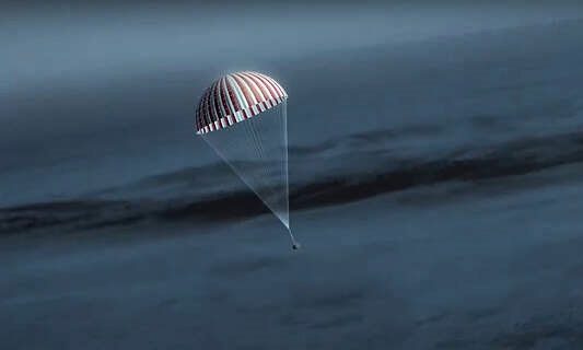 The sample capsule landing on Earth with parachute support.