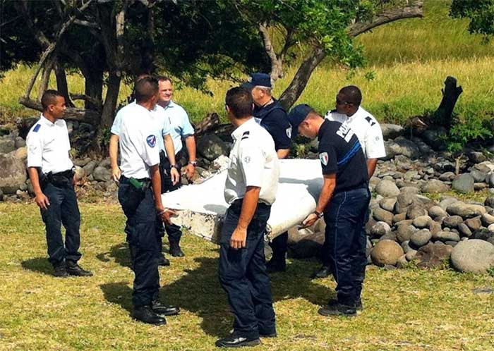 Police carry a piece of aircraft debris found on Réunion Island