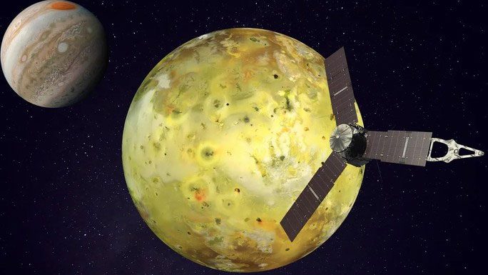 Io with the Juno spacecraft in the foreground and Jupiter in the background