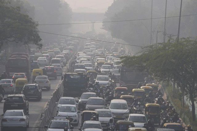 Vehicles moving through fog in New Delhi, India.