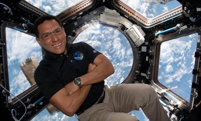 Astronaut Frank Rubio takes a photo in front of the dome window of the ISS.