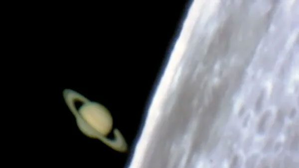 Saturn appearing behind the Moon.