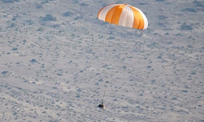 A mock sample return capsule in a drop test on the Utah desert.