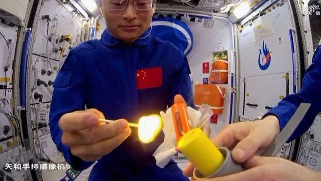 Chinese astronauts lighting a candle on the Tiangong space station.